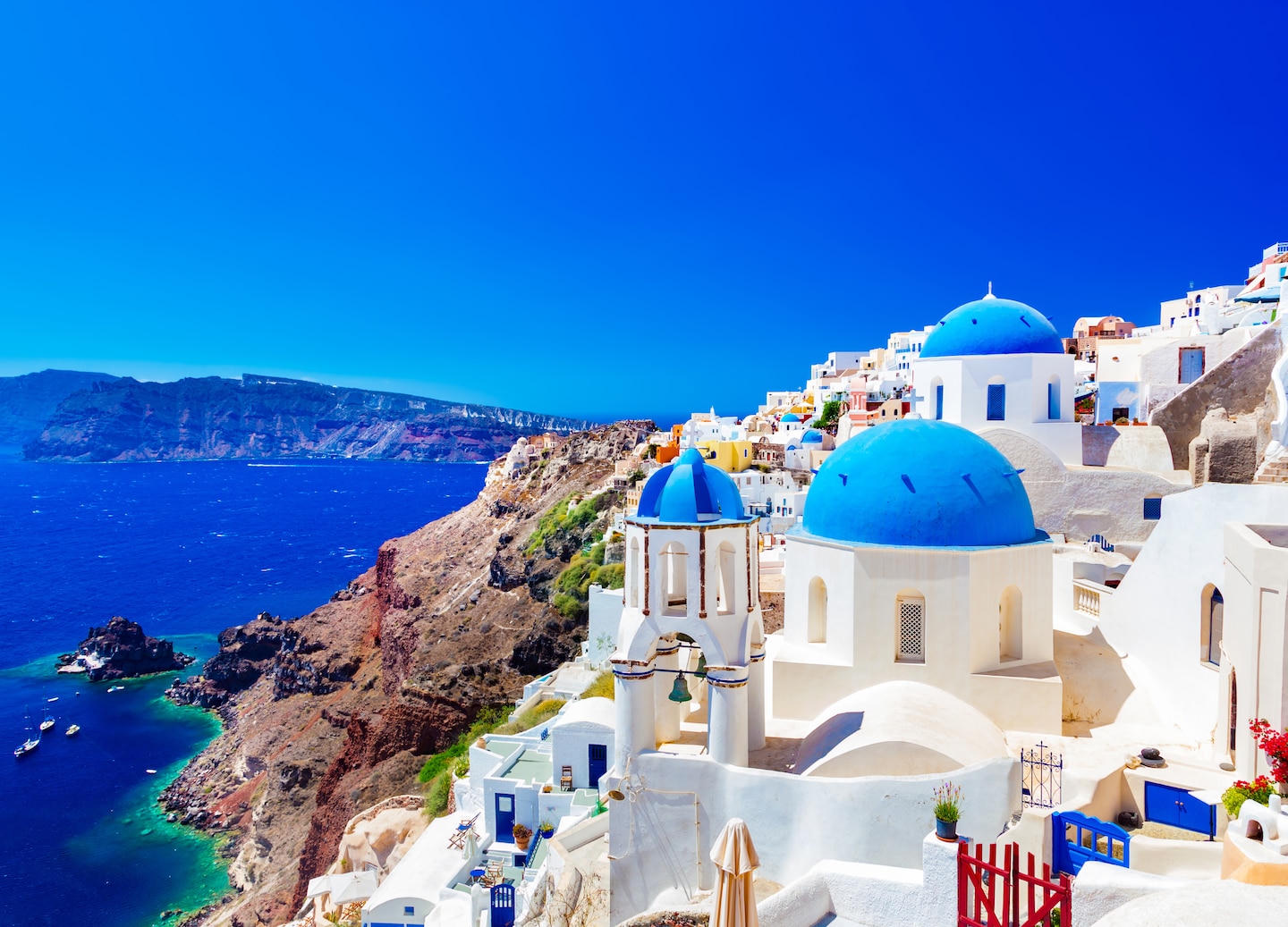 Whitewashed buildings and blue domes above the caldera in Santorini