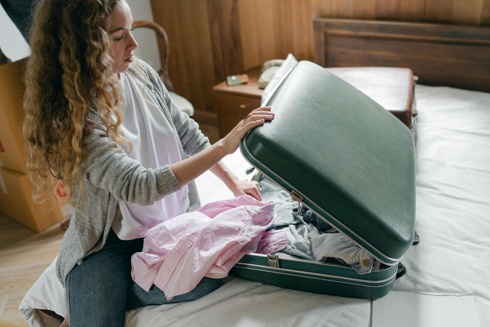 Open suitcase on a bed, mid-pack